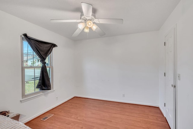 unfurnished room with ceiling fan, light hardwood / wood-style flooring, and a textured ceiling