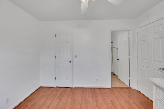 unfurnished bedroom with ceiling fan, ensuite bathroom, and light hardwood / wood-style floors