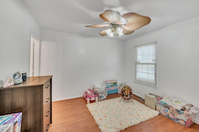 recreation room with ceiling fan and light hardwood / wood-style flooring