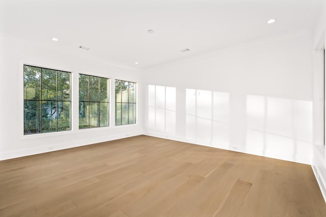 spare room featuring ornamental molding and light wood-type flooring