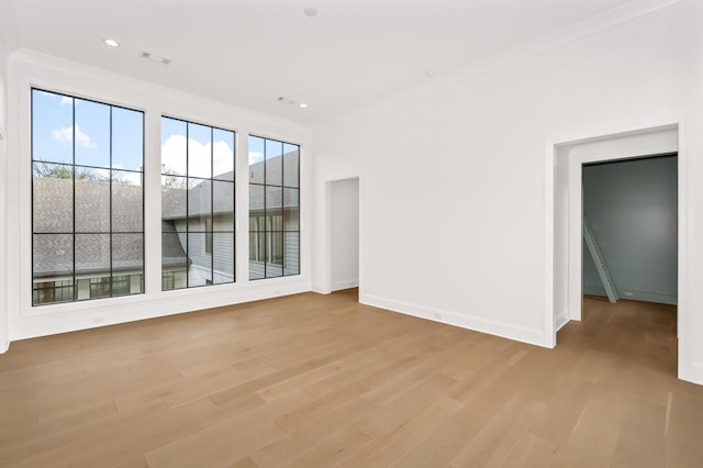 unfurnished room featuring crown molding and light hardwood / wood-style flooring