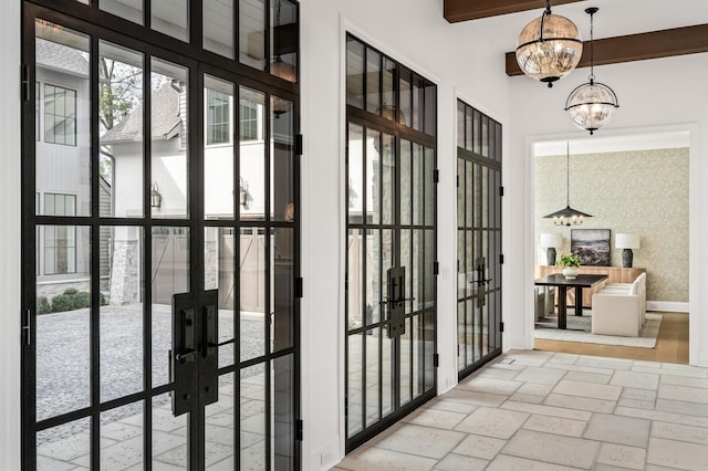 entryway with french doors, beamed ceiling, and a notable chandelier