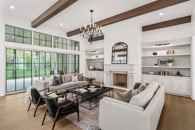 living room with beamed ceiling, built in features, a notable chandelier, and light hardwood / wood-style flooring