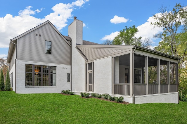 back of property with a sunroom and a yard