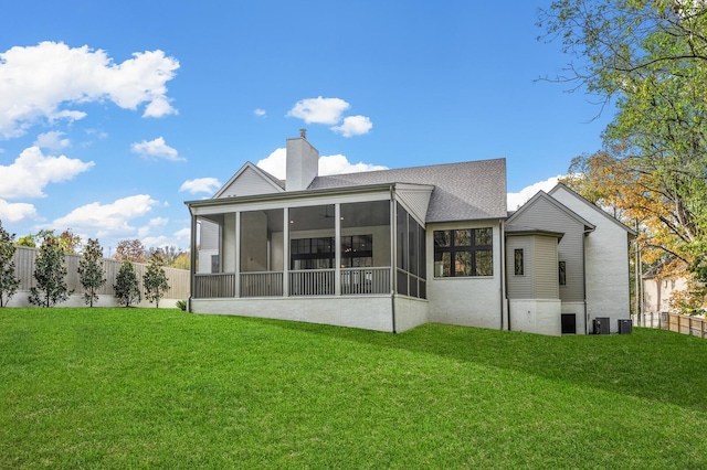 rear view of property with a lawn and a sunroom