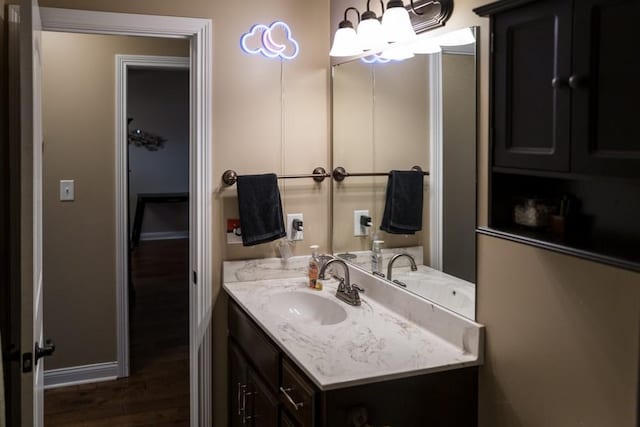 bathroom with hardwood / wood-style flooring, vanity, and a notable chandelier