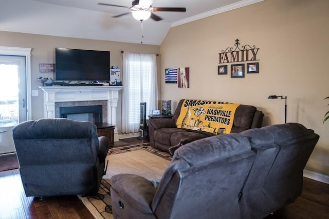 living room featuring hardwood / wood-style floors, vaulted ceiling, a wealth of natural light, and a tiled fireplace