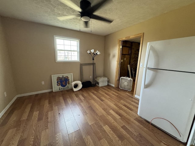 interior space with ceiling fan, hardwood / wood-style flooring, and a textured ceiling