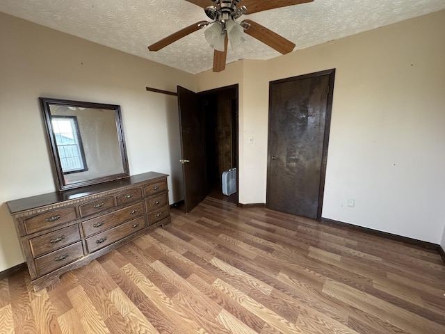 unfurnished bedroom featuring ceiling fan, a textured ceiling, and light wood-type flooring