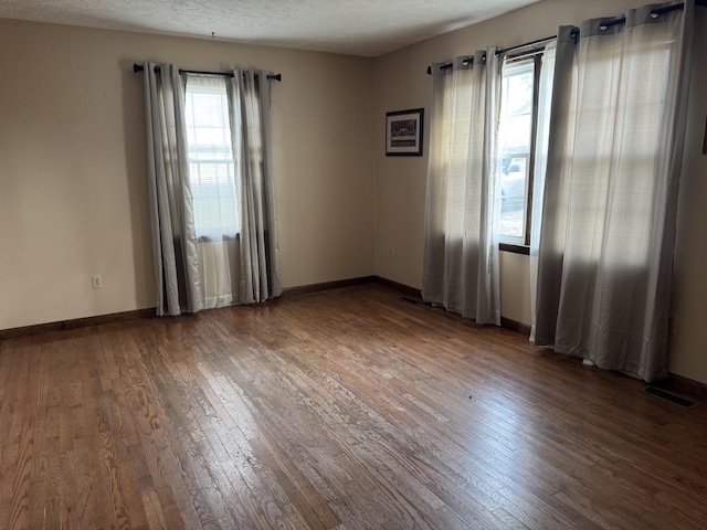 empty room featuring hardwood / wood-style floors and a textured ceiling