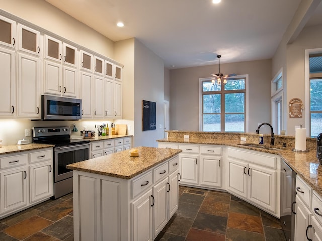 kitchen with white cabinetry, appliances with stainless steel finishes, kitchen peninsula, and sink