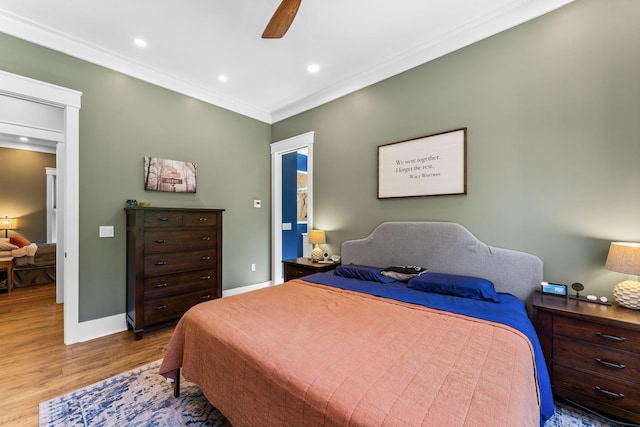 bedroom featuring ceiling fan, ornamental molding, and light hardwood / wood-style flooring