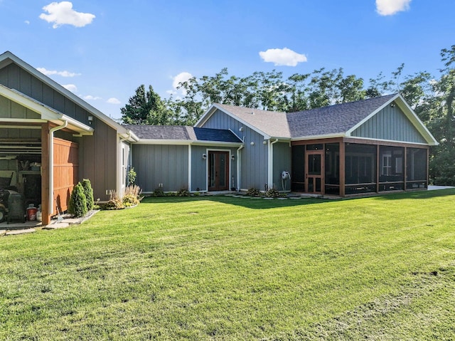 rear view of house featuring a yard and a sunroom