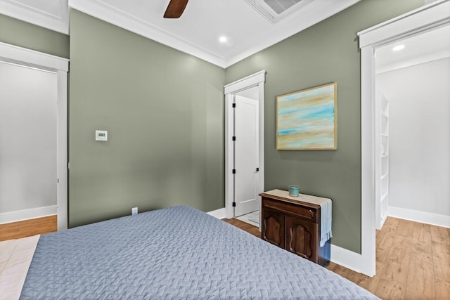 bedroom featuring crown molding, light hardwood / wood-style floors, and ceiling fan