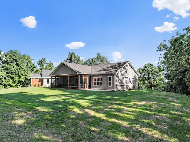 rear view of house with a yard and a sunroom