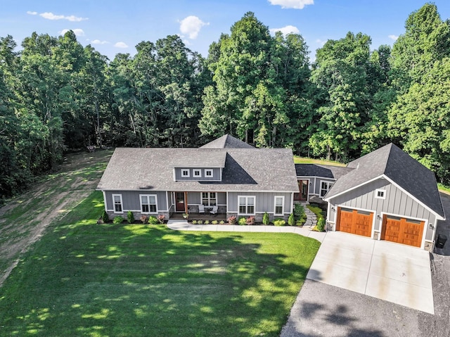 view of front of property featuring a porch, a garage, and a front lawn