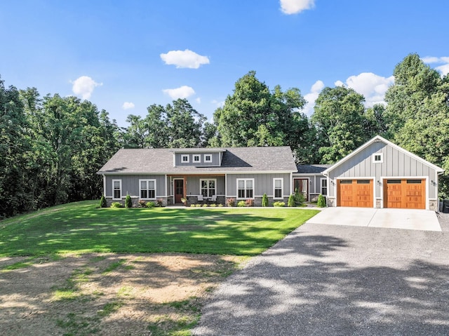 view of front facade featuring a garage, a front yard, and covered porch