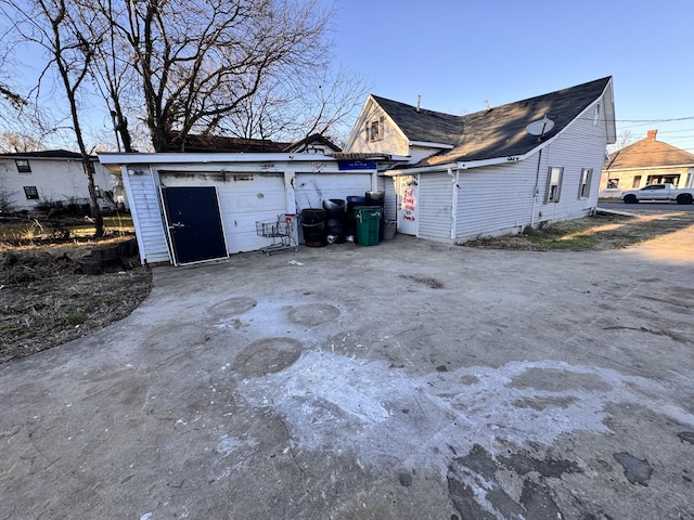 exterior space with a garage and an outbuilding