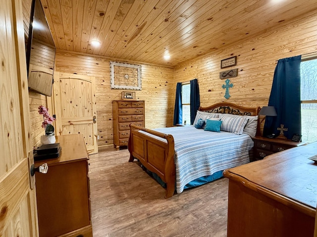 bedroom with wooden ceiling, wood walls, and wood finished floors