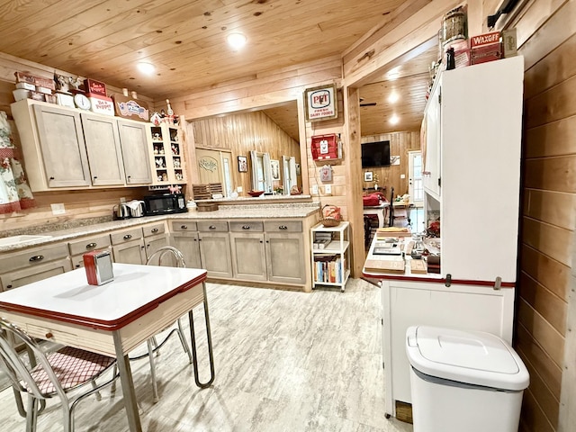 kitchen with wood walls, wood ceiling, light wood-style flooring, and light countertops