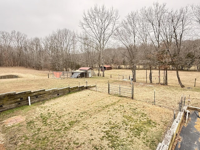 view of yard with an outbuilding, a pole building, a rural view, and fence