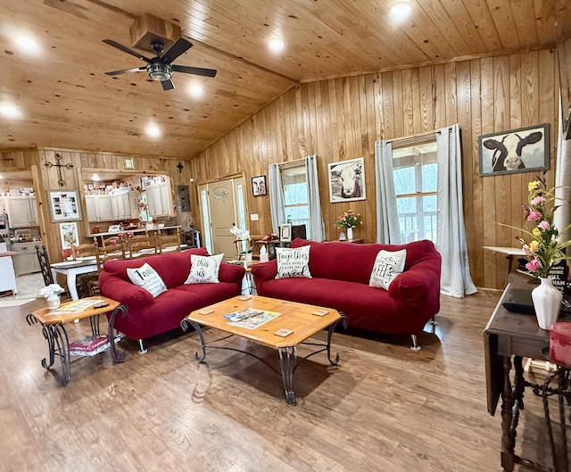 living room featuring wooden walls, a ceiling fan, lofted ceiling, wooden ceiling, and wood finished floors