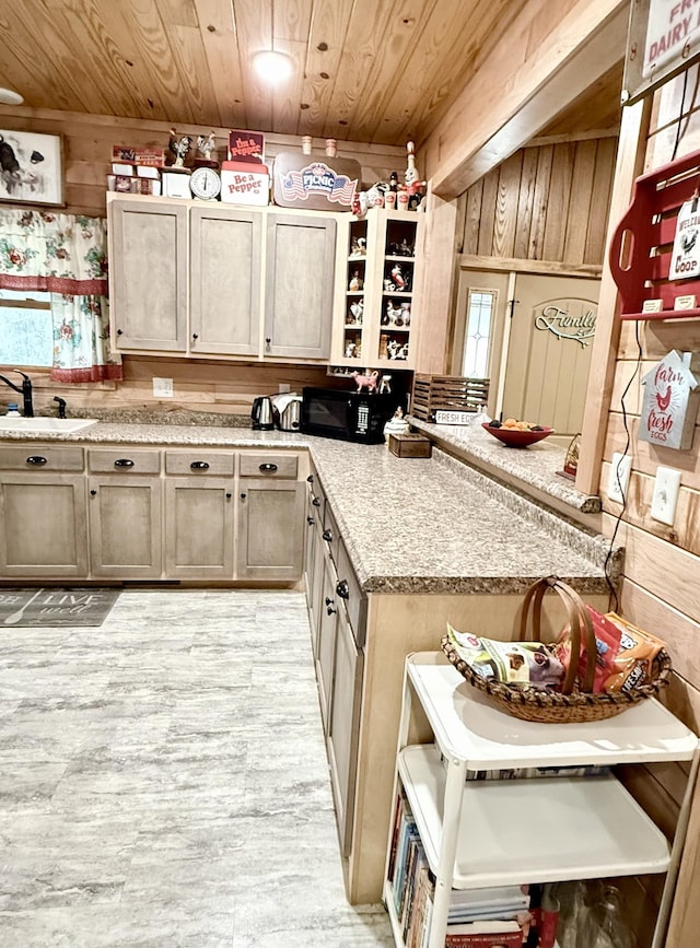 kitchen with wood ceiling, wood walls, a peninsula, and a sink