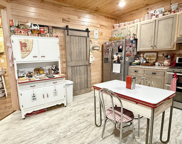 kitchen featuring a barn door, appliances with stainless steel finishes, wooden walls, light wood-type flooring, and wooden ceiling