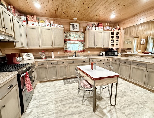 kitchen with range with two ovens, wood ceiling, a sink, wooden walls, and under cabinet range hood