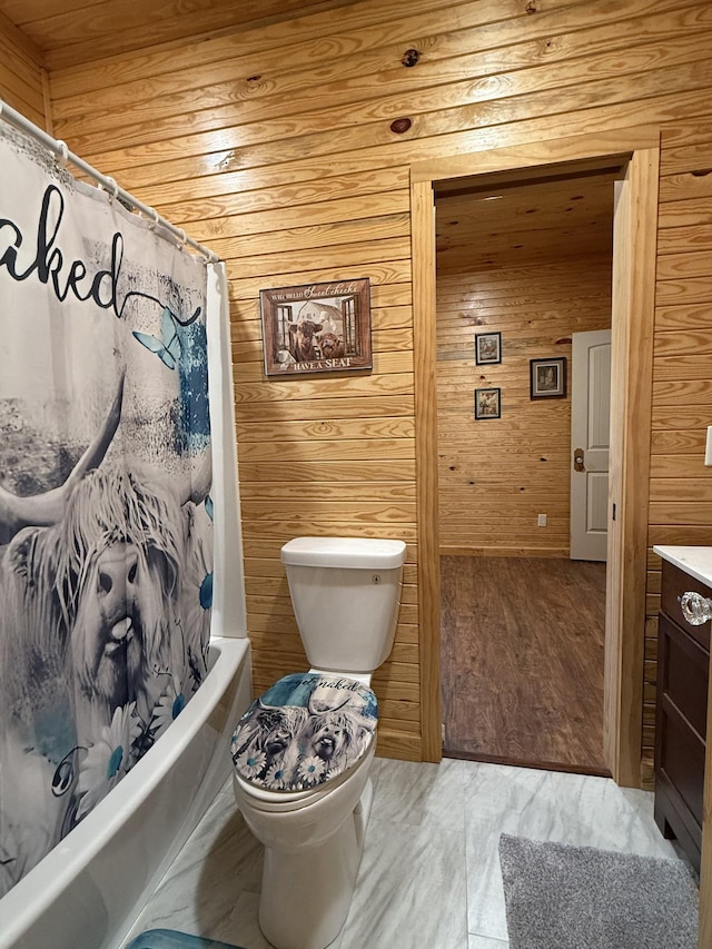 full bath featuring shower / bathtub combination with curtain, toilet, wood walls, vanity, and wood finished floors