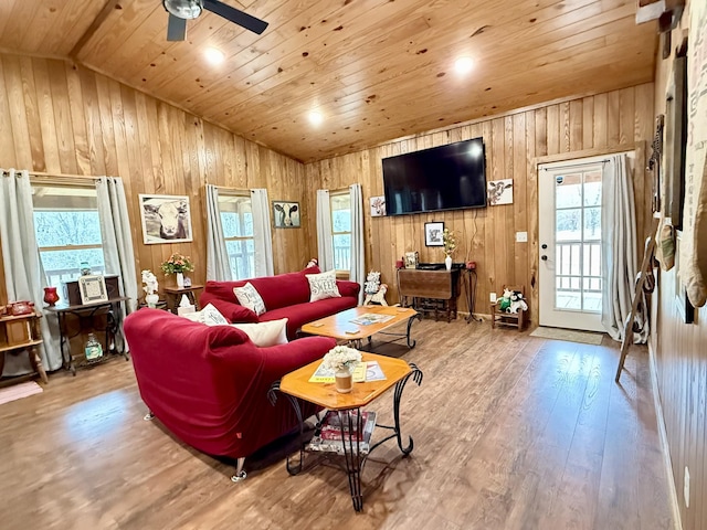 living room featuring a ceiling fan, lofted ceiling, wood ceiling, hardwood / wood-style floors, and wood walls