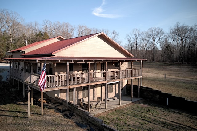 exterior space featuring metal roof, a patio, and a lawn