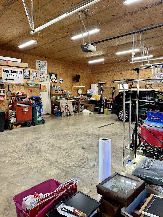 garage with a workshop area and a garage door opener