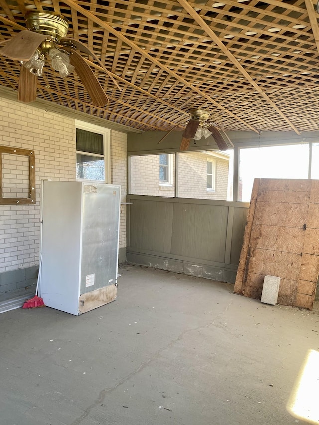 misc room with ceiling fan and brick wall