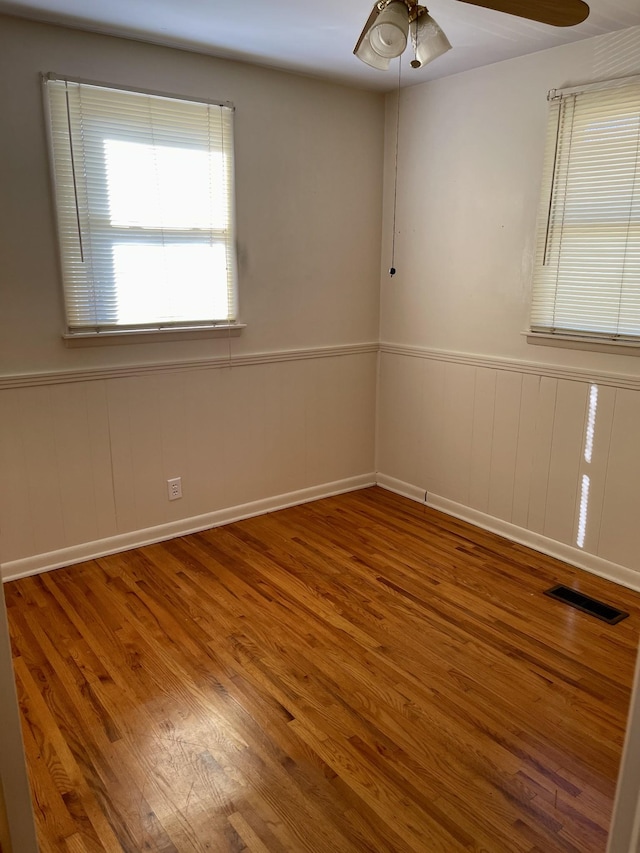 empty room with hardwood / wood-style flooring and ceiling fan