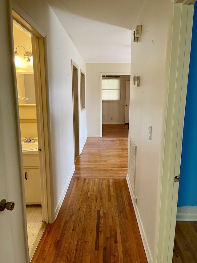 hallway with sink and hardwood / wood-style flooring