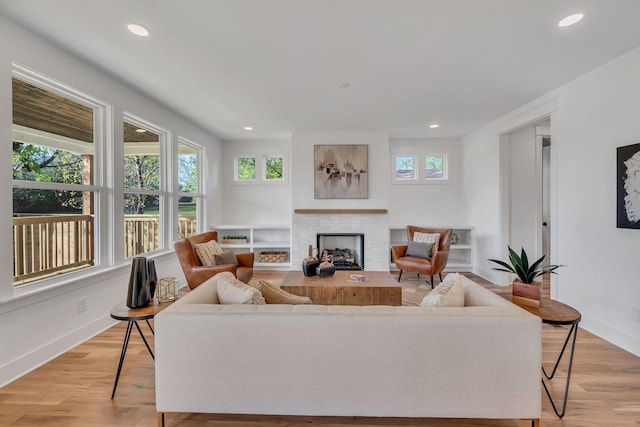 living room featuring light hardwood / wood-style floors and a brick fireplace