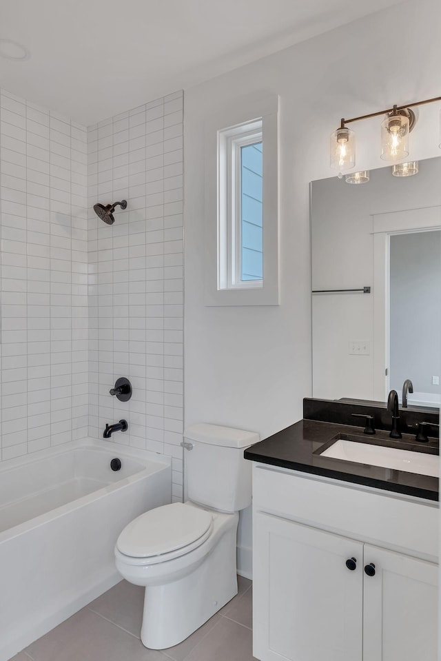 full bathroom featuring tile patterned flooring, vanity, tiled shower / bath combo, and toilet