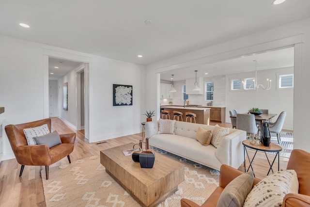 living room featuring light hardwood / wood-style flooring and a chandelier