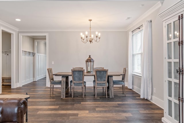 dining room with crown molding, dark wood-type flooring, and a chandelier