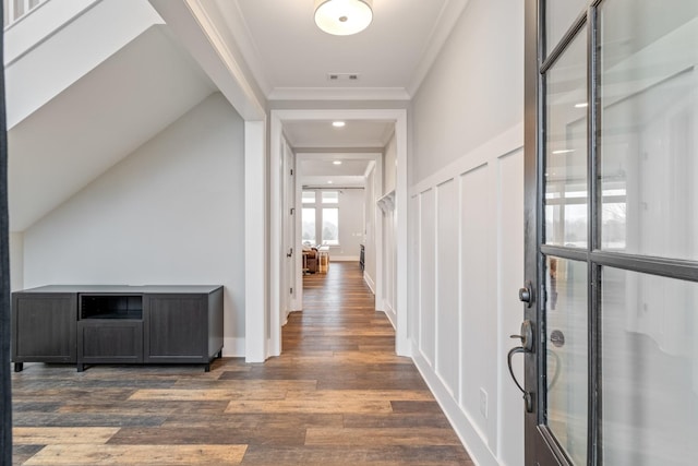 hall with ornamental molding and dark wood-type flooring