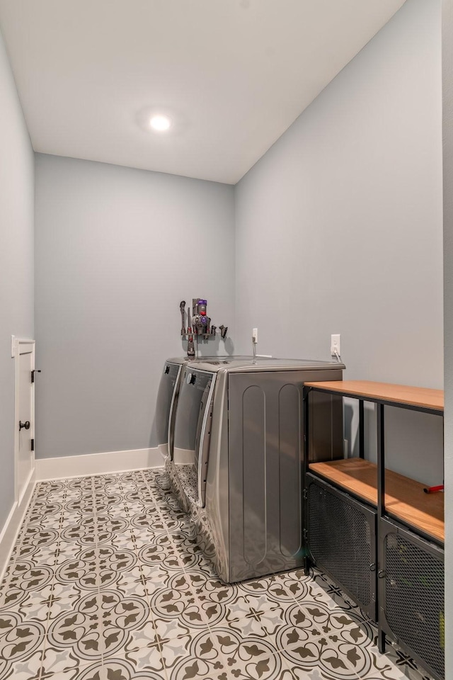 laundry area with light tile patterned floors and washer and clothes dryer