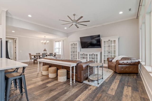 living room featuring crown molding, dark hardwood / wood-style floors, and ceiling fan with notable chandelier