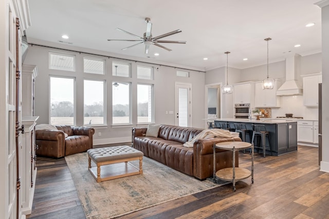 living room with hardwood / wood-style flooring, crown molding, and ceiling fan