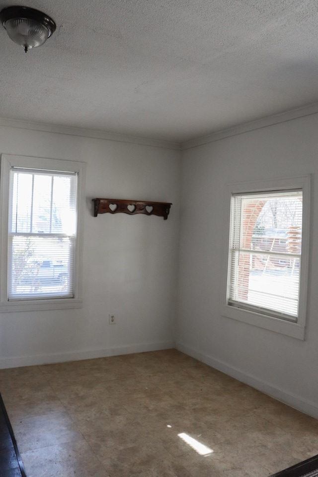 spare room with ornamental molding and a textured ceiling