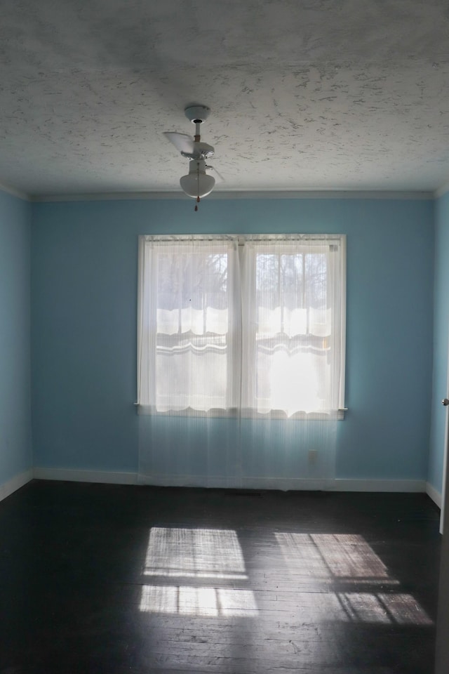 spare room featuring dark hardwood / wood-style flooring, ceiling fan, crown molding, and a textured ceiling