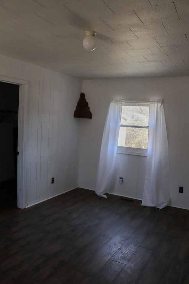 unfurnished room with dark hardwood / wood-style flooring