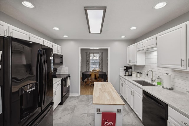 kitchen with sink, white cabinetry, wooden counters, black appliances, and backsplash