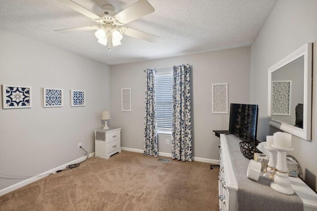 office space with ceiling fan, light colored carpet, and a textured ceiling