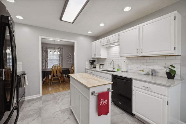 kitchen featuring sink, white cabinetry, a center island, black appliances, and wood counters